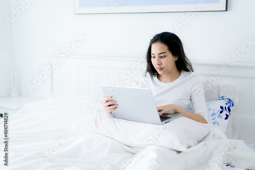 Young woman working from home in bedroom