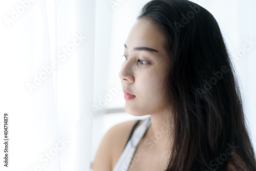 Portrait of young woman in a bed room