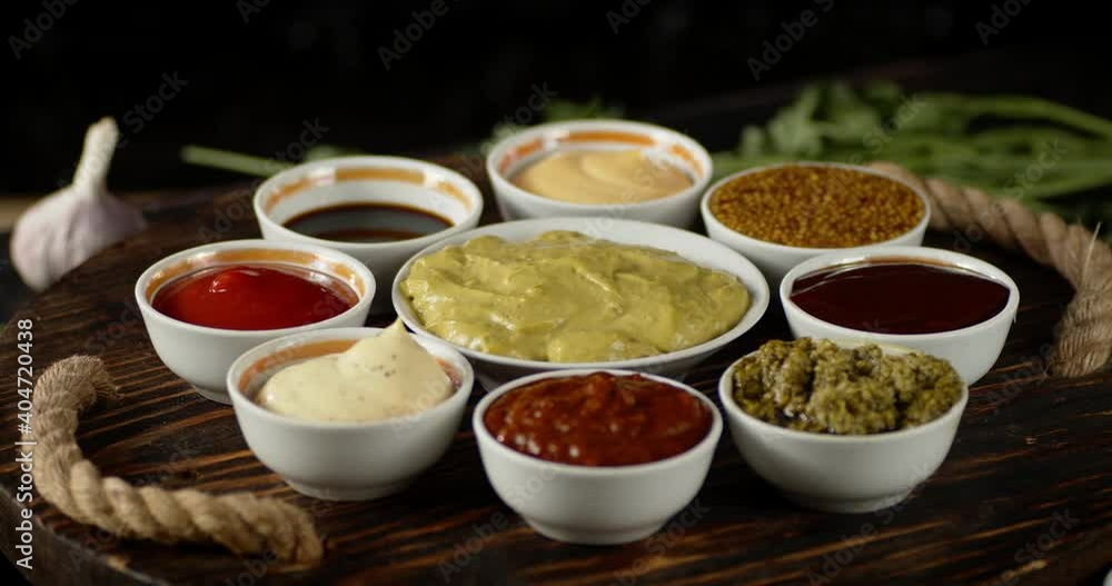 The wooden tray with different aromatic sauces rotates. The wooden tray with different aromatic sauces rotates.