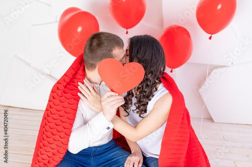 valentine's day, a couple in love kissing behind a red heart