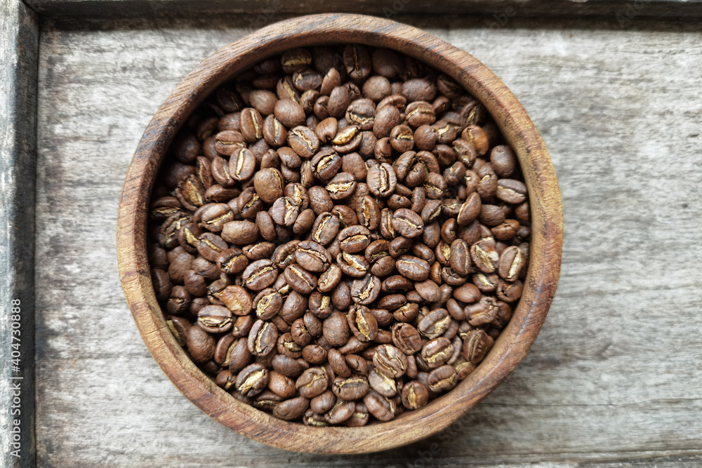 Fototapeta premium Close up of coffee beans in wooden bowl for background