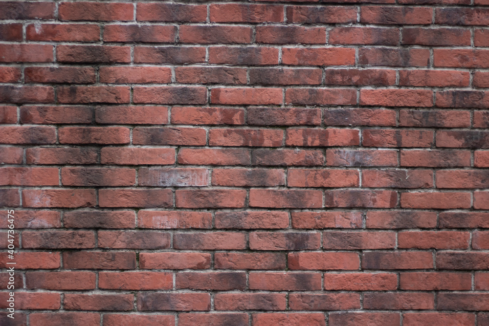 Brick texture from old stone. 18th century brick wall. Old burnt brick masonry. Shooting details close-up. Aged red clay color. Rectangular blocks laid out in rows and held together with cement. Brick texture from old stone. 18th century brick wall. Old burnt brick masonry. Shooting details close-up. Aged red clay color. Rectangular blocks laid out in rows and held together with cement.