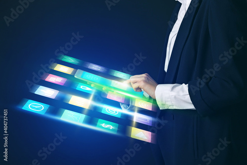 Woman with tablet computer using virtual screen on dark background. Concept of digital marketing