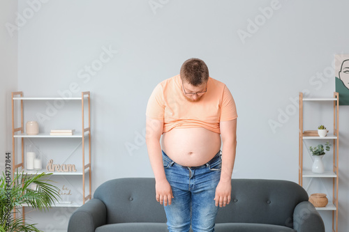 Sad overweight man at home....