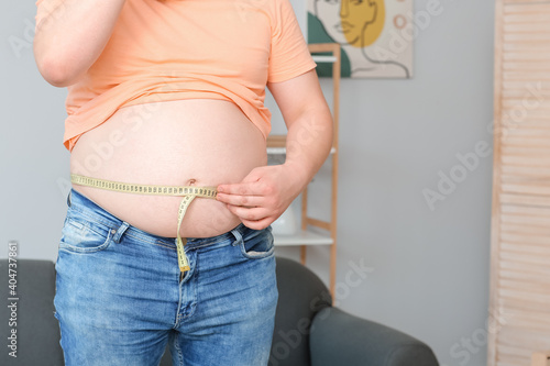Overweight man with measuri...