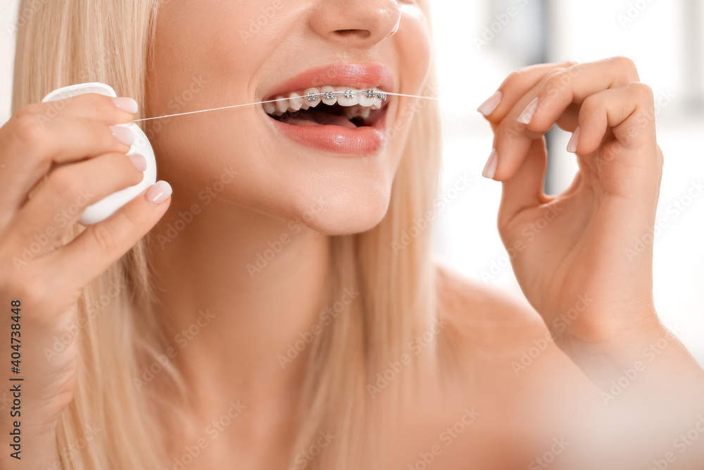 Young woman with dental braces and floss, closeup Young woman with dental braces and floss, closeup