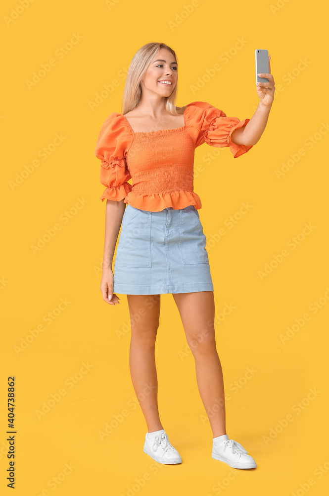 Teenage girl taking selfie on color background Teenage girl taking selfie on color background