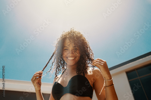 Young African woman in bikini enjoying summer weather at the pool
