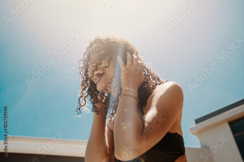 Young African woman in bikini enjoying summer weather at the pool