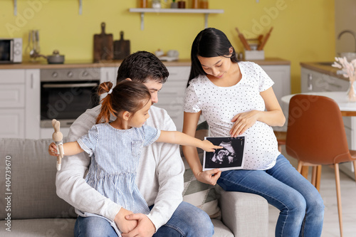 Pregnant Asian woman with her family at home