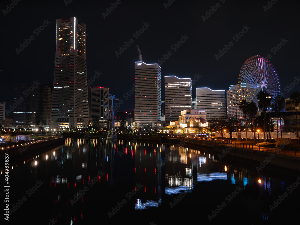 Naklejka premium 日本の横浜の夜景。綺麗な街のイルミネーションが反射した川の水面。
