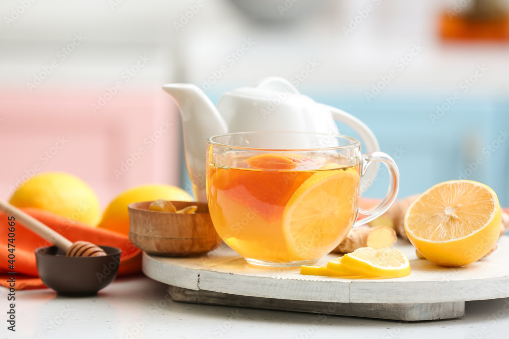 Board with cup of aromatic tea with lemon, ginger and honey on table Board with cup of aromatic tea with lemon, ginger and honey on table