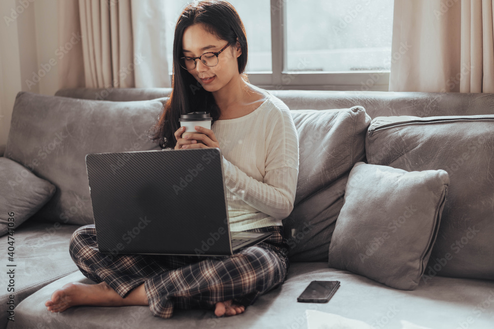 Young woman working on laptop and drinking coffee at home. Beautiful busineeswoman working at home and take a break. Working at home during Coronavirus or Covid-19 quarantine. Young woman working on laptop and drinking coffee at home. Beautiful busineeswoman working at home and take a break. Working at home during Coronavirus or Covid-19 quarantine.