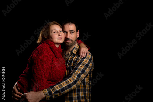 Middle-aged couple with attitude of love posing on a black studio background