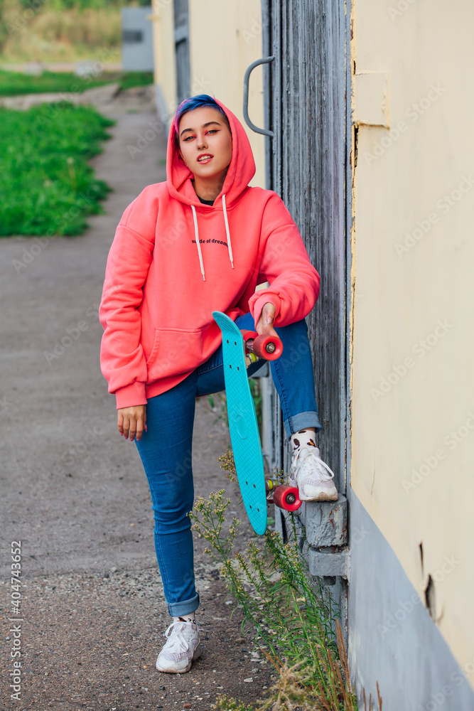 Φωτογραφία Stylish young woman holding skateboard in hand. Youth concept.