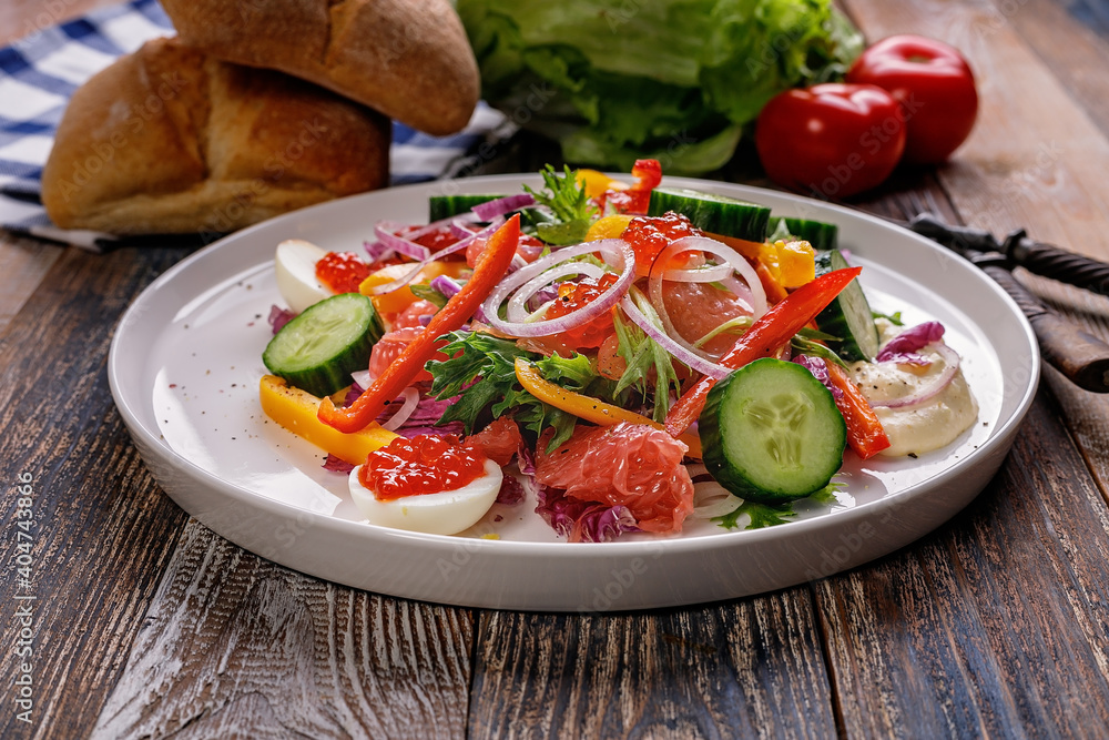 Delicious and healthy food. Salad with smoked trout, grapefruit, fresh cucumber, purple Chinese cabbage sweet peppers. Mediterranean diet recipes. Low calories meal.