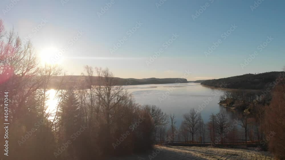 Serene Lake Reveal, Sun Shining Through Bare Trees, Aerial Rising Serene Lake Reveal, Sun Shining Through Bare Trees, Aerial Rising