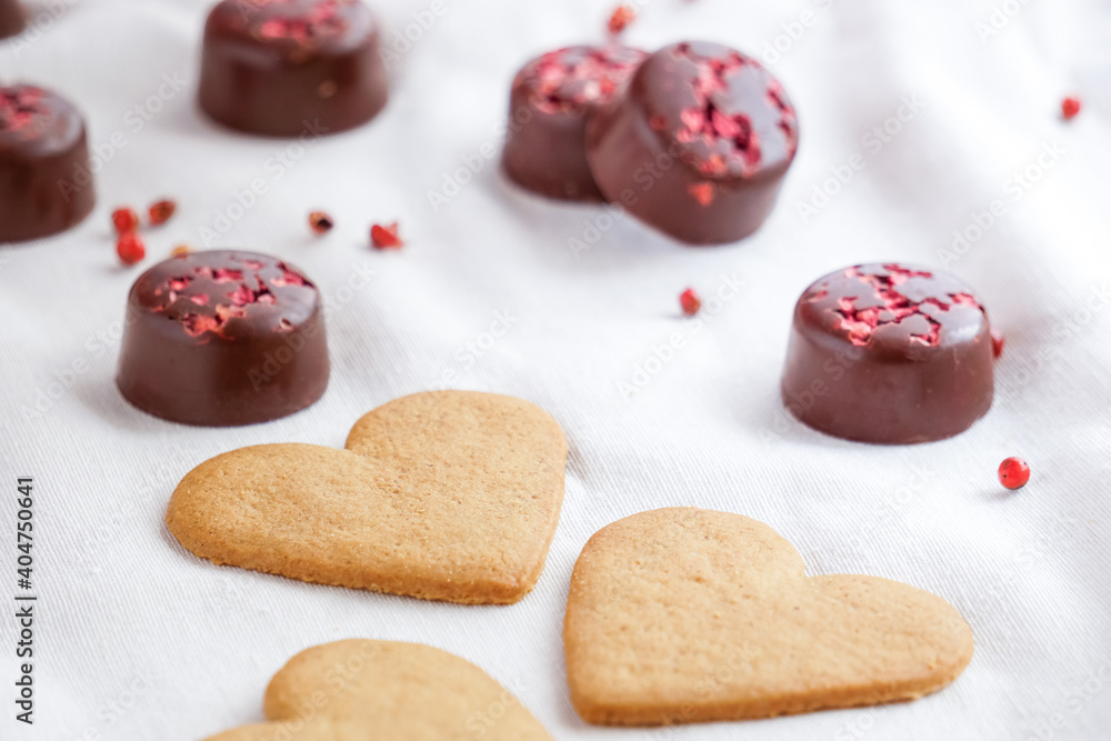 Close up view of Valentine's Day cookies with chocolates on the background. Selective focus. Valentine's Day background Close up view of Valentine's Day cookies with chocolates on the background. Selective focus. Valentine's Day background