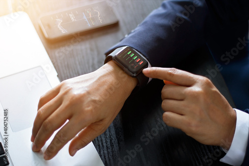 Businessman checking forex trading, stock market price from smart watch. Fintech intelligence technology enables user flexible and digital solution on financial investment in stock exchange trading.