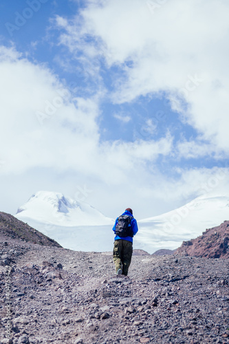 tourist climbs the mountain on the background of Elbrus