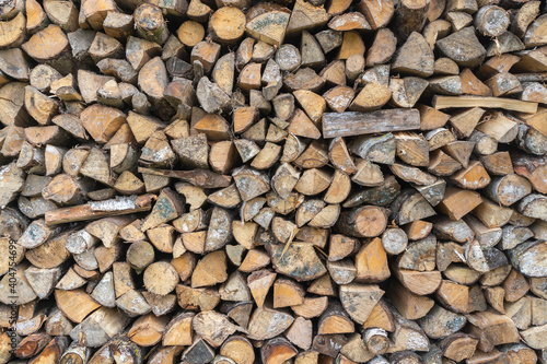 Background of dry chopped firewood logs in a pile