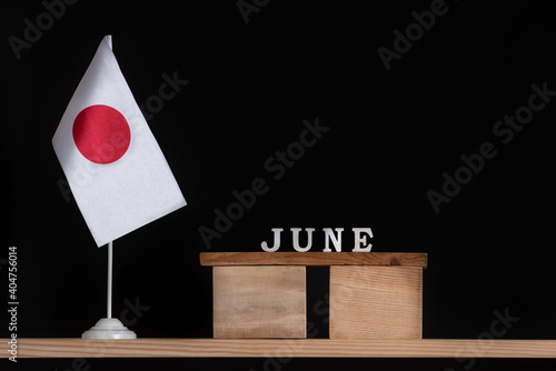 Wooden calendar of June with Japan flag on black background. Dates of Japan in June