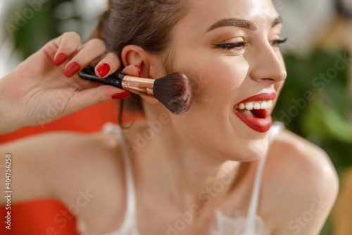 Beautiful young happy caucasian woman at cozy home with cosmetics at sunny morning