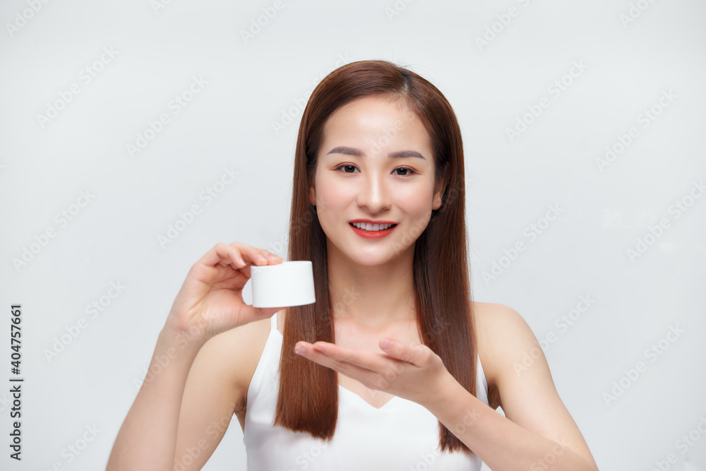 Smiling young woman holding cream bottle Smiling young woman holding cream bottle