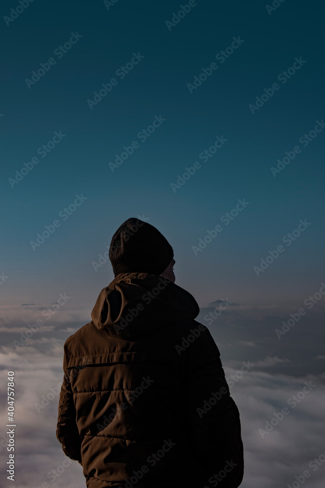Man in a jacket in the mountains. The guy dreams and looks into the distance. Man in a jacket in the mountains. The guy dreams and looks into the distance.