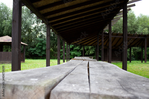 Old wooden bench and a table made of solid round timber in a gazebo  outdoor recreation