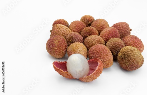 Lychees on white background, one open showing the pulp