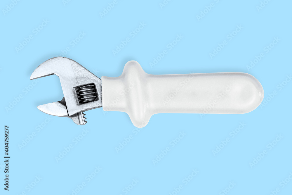Adjustable metal wrench with a rubberized handle on a blue background. Adjustable metal wrench with a rubberized handle on a blue background.