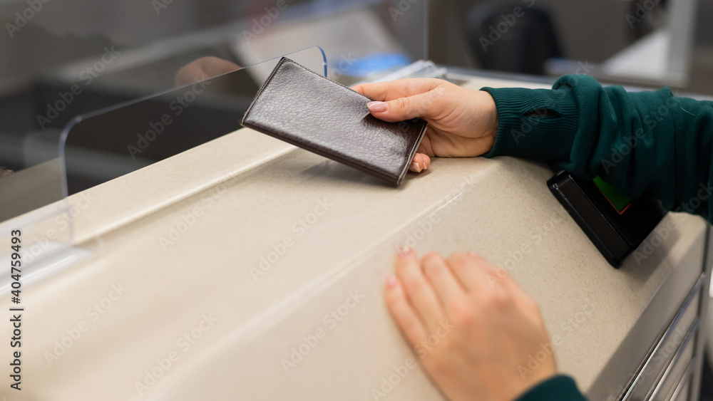 Obraz premium Faceless woman at the airport holding out passport assistant to the check-in counter.