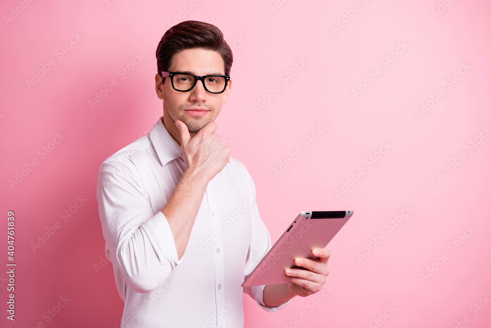 Portrait of serious guy type tablet hand face wear spectacles white shirt isolated on pink color background