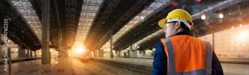 Back view of Manager industrial engineer walking and checking structure and of construction railway of high speed on station background. Technology and engineering. transportation and logistics.