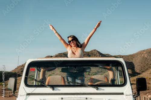 Latin woman enjoying an adventure trip in a 4x4 vehicle