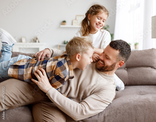 Kids playing with father on sofa