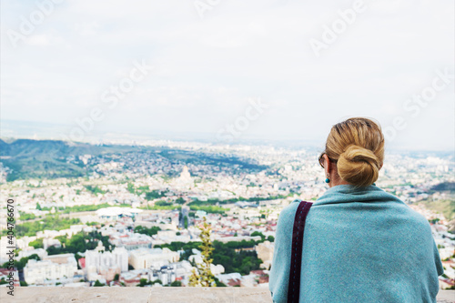 Back view of pensive lonely young woman looking into the distance