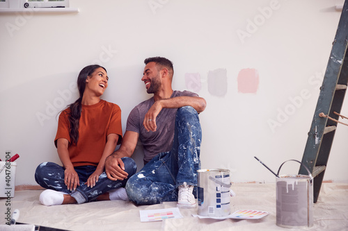 Obraz na plátně Couple Taking A Break From Painting Test Squares On Wall As They Decorate Room I