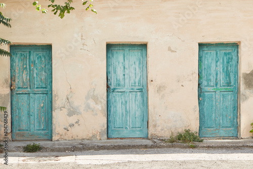 old turquoise doors against a beige wall