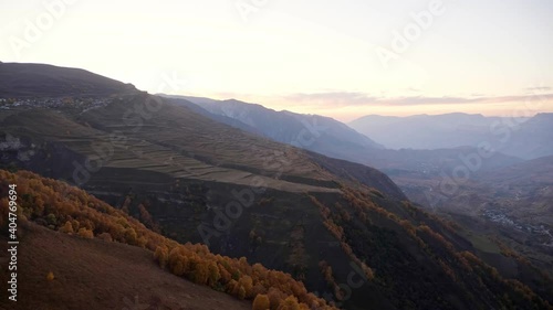 Amazing wide valley with picturesque mountains covered with autumn forest and green meadows under clear sky in evening panoramic view photo