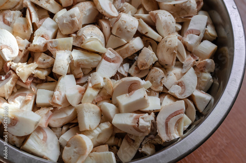 Raw mushrooms diced in a metal bowl.