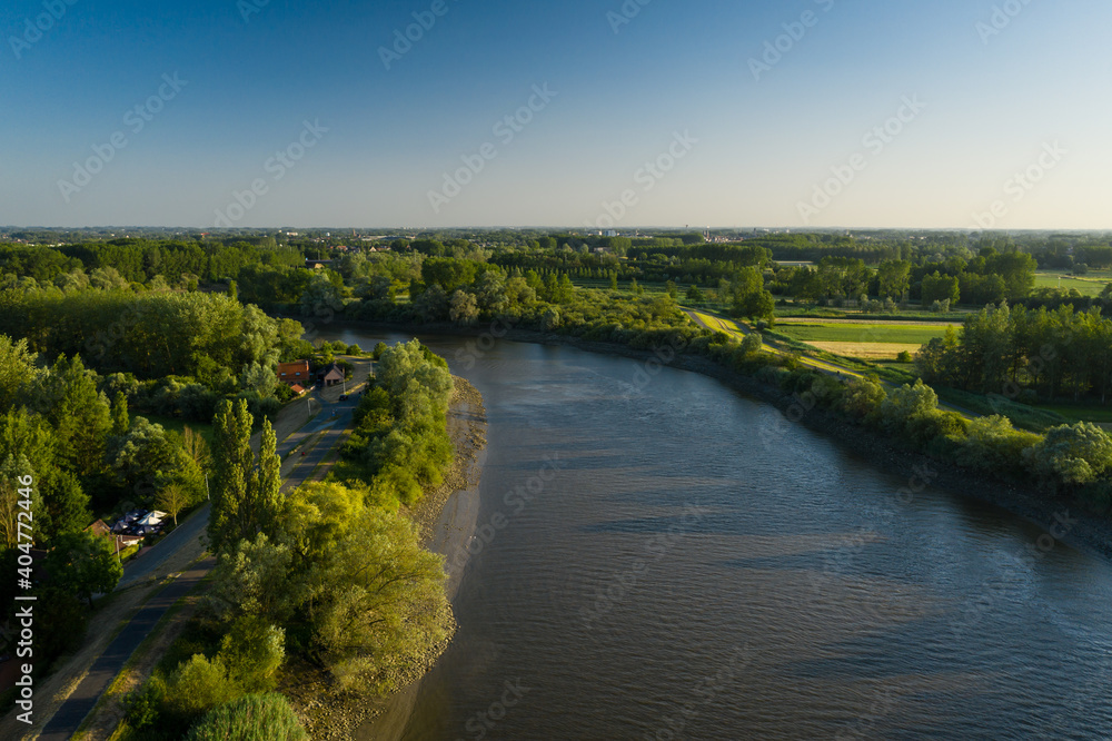Aerial view of the Scheldt river, while passing the picturesque village of Vlassenbroek