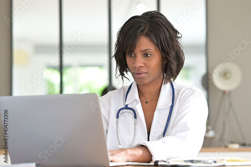 Portrait of woman practitioner working in office on laptop