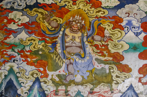 Colorful traditional wall painting of wrathful deity riding green horse in Gangtey gompa or monastery, Phobjikha valley, Bhutan