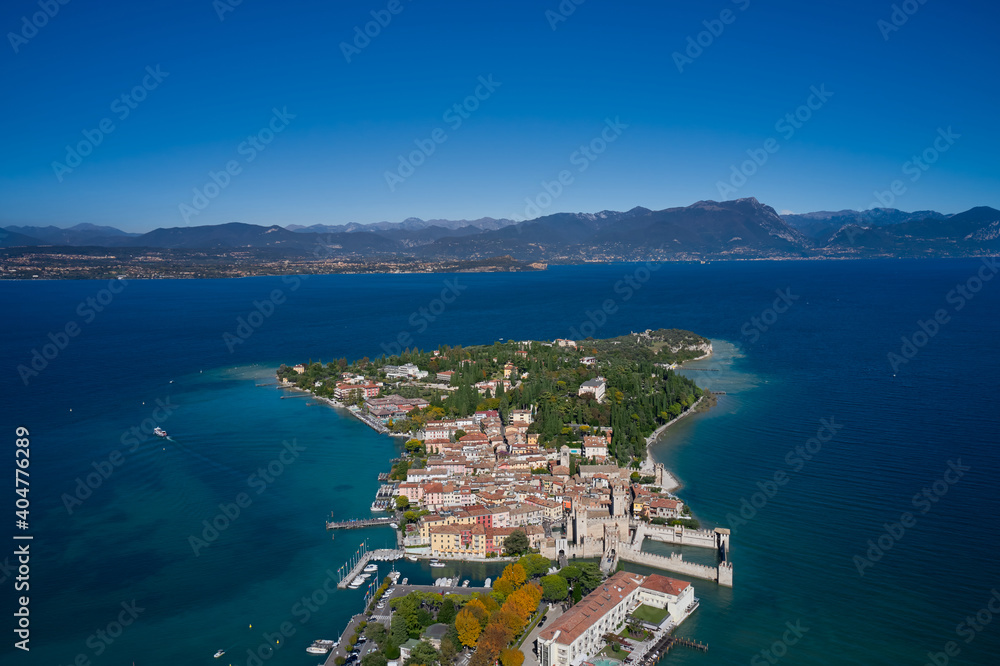 Top view of the town of Sirmione, Italy. Lake Garda, a tourist destination in northern Italy. Trees in the autumn season. Autumn in Italy on Lake Garda, Sirmione peninsula.