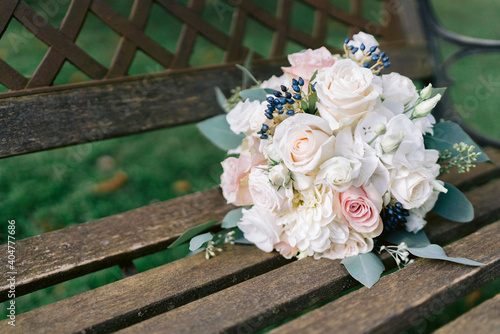 Brautstrauß mit weißen Rosen liegt auf einem Stuhl © Kevin Sloniecki