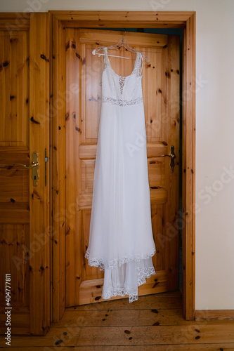 weißes boho Vintage Hochzeitskleid hängt an der Tür