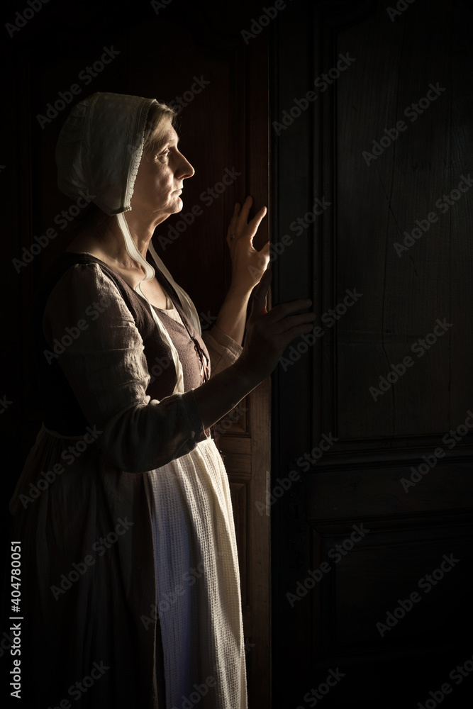 Woman waiting at the door in darkness