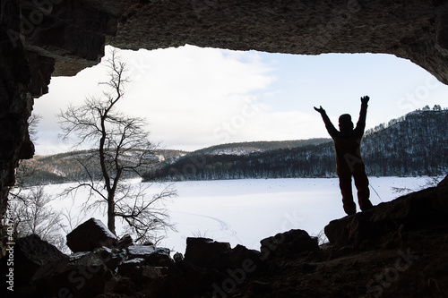 entrance to the cave, the silhouette of a man against the sky, a huge hole in the rock, see from the cave on the river, winter travel, Russia, the southern Urals